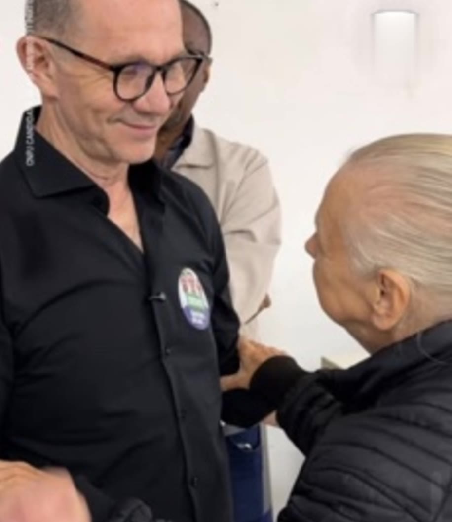 Rafael Silva Jr. cumprimenta uma moradora durante visita